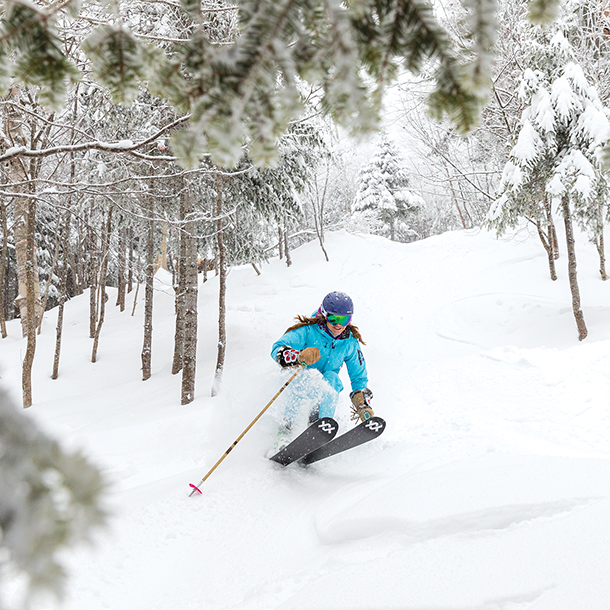 Snowboarder going downhill on snowy mountain